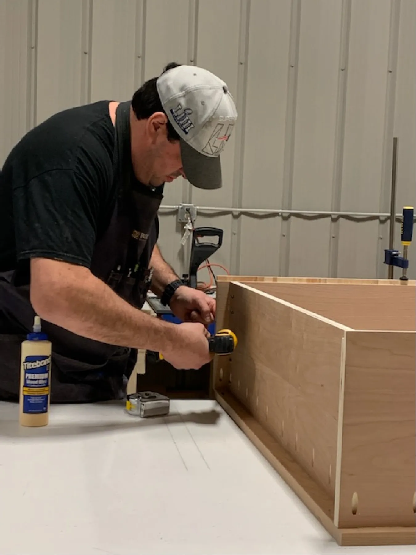 Craftsman drilling and assembling a cabinet frame